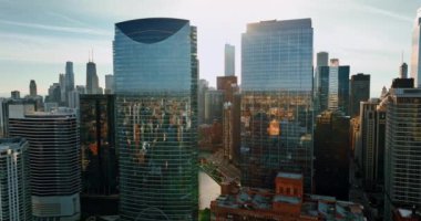 Chicago manzarası yüksek binaların cam cephelerini yansıtıyor. Chicago Nehri şehir manzarasını geçiyor. Gün batımında en üst görünüm.