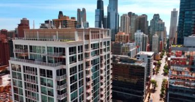 Açık balkonları olan yüksek katlı güzel bir bina boyunca yükseliyor. Güneşli bir günde Şikago şehir merkezinde çarpıcı gökdelenler....
