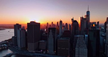 Günbatımında New York, Manhattan 'ın göz kamaştırıcı manzarası. Doğu Nehri 'nin yukarısındaki İHA görüntüleri arka planda turuncu güneşli şehir manzarasını gösteriyor..
