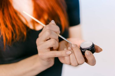 Makyajını iyi ışıklandırılmış bir fırçayla yapan kişi. Bir kişi, bir fırça kullanarak makyaj yapar.