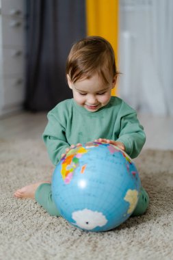 Gündüz vakti evin içinde renkli bir dünyayı keşfeden küçük bir çocuk. Yeşiller içinde bir çocuk dünyayı keşfediyor.