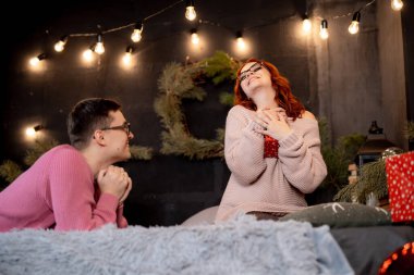 Çift, kapalı bir alanda keyifli bir anı paylaşıyor. Bir çift, iç mekandaki şenlik ortamında kahkahalarla dolu yürek ısıtan bir etkileşimden hoşlanıyor..