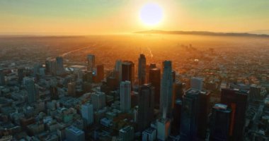 Günbatımında, Los Angeles, Kaliforniya 'nın engin manzarasının üzerinde kocaman sıcak bir güneş diski. Şehir merkezinde ve şehrin yukarısında altın saatinde. Üst görünüm.