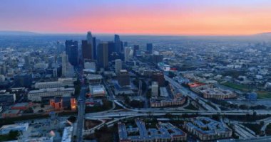 Yoğun otoyollar modern Los Angeles, Kaliforniya, ABD şehir merkezinde daireler çiziyor. Gün batımında canlı şehrin hava manzarası.