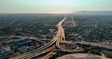 Modern Los Angeles 'ın otobanlarından çok sayıda araba geçiyor. Amerikan şehrinin yukarısındaki işlek yol kavşağının üst görüntüsü.