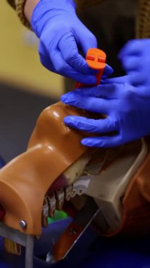 Sahte bir kafa üzerinde tıbbi uygulama. Bir doktor yardımıyla manken üzerinde tıbbi teknikler öğreten bir öğrenci. Yakın plan. Dikey video