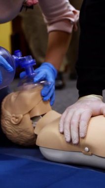 Bir kukla üzerinde eğitim pratiği. Öğrenciler hayat kurtarmak için bir manken üzerinde canlandırma tekniği üzerinde çalışıyorlar. Kardiyopulmoner resüsitasyon. Dikey video