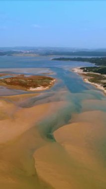 Geniş kumlu sahil, kum yığınlarının arasında biraz su var. Yukarıdan bakıldığında Azores 'in doğasının güzel bir manzarası var. Dikey video.