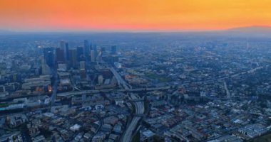 Gün batımında Los Angeles 'ın puslu manzarası. Turuncu gökyüzünün altındaki engin şehir manzarasına hava perspektifi.