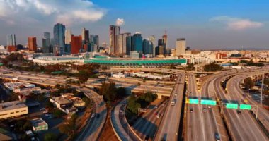 Los Angeles, California, ABD otobanlarında trafik çok hareketli. Gün batımının ışığında çeşitli gökdelenlerden oluşan bir gruba daha yakın uçmak.