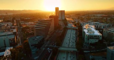 İş gününün sonunda birden fazla araç otoyol kenarına hareket ediyor. Los Angeles, Kaliforniya, ABD 'de trafik. Gün batımında en üst görünüm.