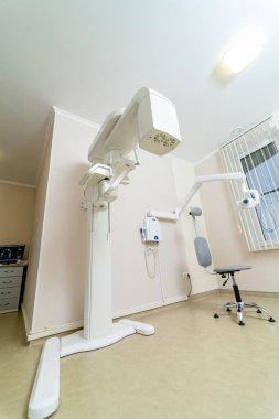 Hastalar için modern diş muayenesi odası. Gelişmiş ekipman ve rahat bir hasta sandalyesinin bulunduğu iyi ışıklandırılmış bir diş muayenesi odası.