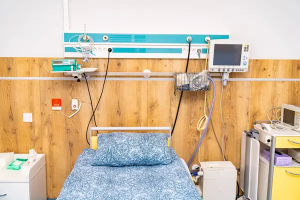 stock image Hospital room with medical equipment and bed setup. A hospital room featuring a neatly made bed, essential medical equipment