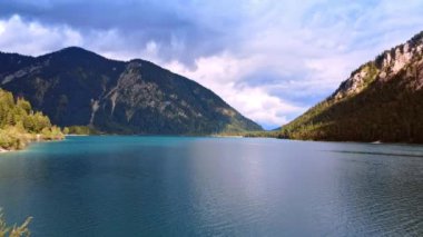 Çam ağaçlarıyla kaplı güzel dağların üzerindeki su manzarası. Lichtenstein, Avrupa 'nın vahşi doğası.