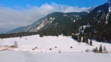 Güneşli bir günde İsviçre Alpleri 'nin muhteşem manzarası. Karlı vadideki birkaç ahşap kulübenin üst görüntüsü. Lichtenstein.