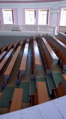 Üniversitede konferans salonu. İçerideki eğitim merkezinin panoramik görüntüsü. Salgın sırasında boş masaları olan büyük bir salon. Dikey video