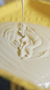 Evi yenilemek için hafif boya. İşçi boya tepsisine krem rengi döküyor. Daire dekorasyonu ve ev inşaatı. Yakın plan. Dikey video
