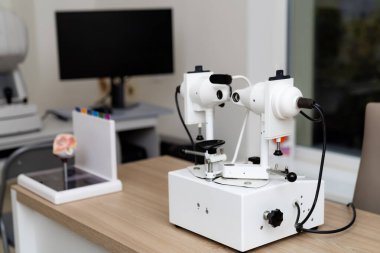 Modern bir laboratuvar çalışma alanına optik ekipman kurulmuş. Bilimsel araştırmalar için hassas aletleri vurgulayan özel bir optik cihaz modern bir laboratuvarda bir masanın üzerinde duruyor..
