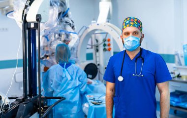 Cerrah hastanede robotik ameliyata hazırlanıyor. Bir tıbbi uzman, bir cerrahi ekibinin robot sistemi kullanması için hazır bekliyor.