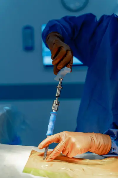 stock image Surgeon preparing tools for surgery. A medical professional in gloves prepares a surgical instrument for use in an operating room while ensuring a sterile environment.