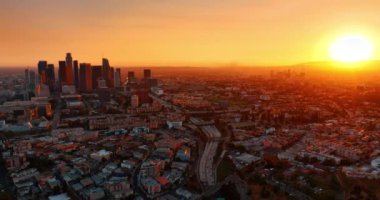 Los Angeles, Kaliforniya, ABD 'nin şehir manzarasını kaplayan yumuşak turuncu ışık. Arabalar şehir merkezine gidip geliyormuş. Hava perspektifi.