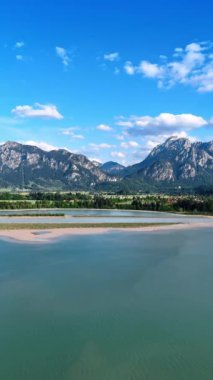 Resimli vadide dağların ve su manzarasının arasında küçük bir kentsel alan yer almaktadır. Liechtenstein, Avrupa 'nın FPV insansız hava aracı görüntüleri. Dikey video.