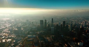 Los Angeles, California, ABD 'nin puslu manzarası. Şehir merkezindeki gökdelenlerin hava görüntüsü. Parlak güneş görüntüyü kör ediyor..