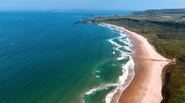 Kumlu sahildeki dalgaların büyüleyici görüntüsü. İrlanda 'nın resimli kayalık kıyıları üst perspektiften.