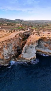 Turistler, beyaz kayalıkların kenarında dururlar. İHA görüntüleri güzel İrlanda kıyı şeridinden yükseliyor. Dikey video.