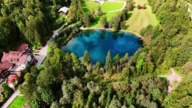 Sıcak bir otel kulübesinin yanında küçük, mavi bir göl. Christlessee Gölü, Oberstdorf, Bavyera Alpleri, Avrupa.