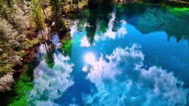 Göle yansıyan güneş ve beyaz bulutlarla dolu inanılmaz masmavi gökyüzü. Christlessee Gölü, Oberstdorf, Bavyera Alpleri, Avrupa.