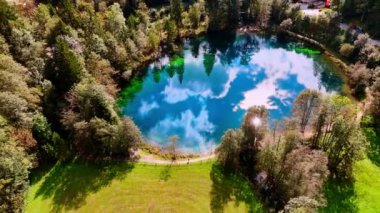 Güneşli bir günde gökyüzünü yansıtan küçük bir gölün üzerinde yükseliyor. Christlessee Gölü, Oberstdorf, Bavyera Alpleri, Avrupa.