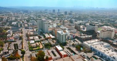 Gündüz vakti ışıl ışıl parlayan bir metropol manzarası. Los Angeles, Kaliforniya, arka planında puslu bir ufuk olan ABD. Üst görünüm.