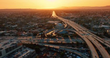 Modern Los Angeles 'ın ulaşım sistemi, Kaliforniya, ABD. Otomobiller gün batımında kavşak, yollar ve otoyollar üzerinden hareket eder. Hava perspektifi.
