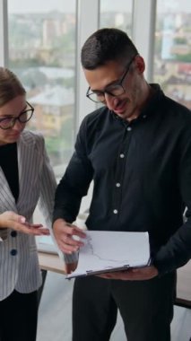 Meslektaşlar dosyalara bakıyorlar. Ofisteki takım arkadaşları danışmanlık ve bilgi paylaşımı yapıyor. Dikey video