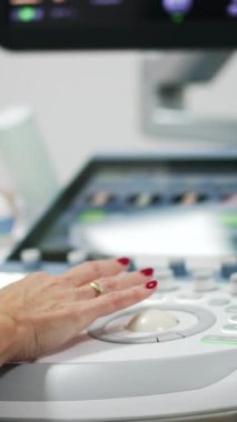 Kadın sonograf ultrason taraması yapıyor. Uzman ekranda bebekle resmedilen bir resme bakıyor..