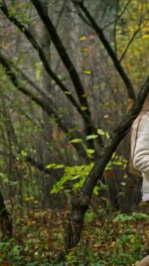 Sonbahar parkında yürüyüş yapan esnek gülümseyen orta yaşlı bayan. Beyaz kadın kahve içer ve sıcak havanın tadını çıkarır..