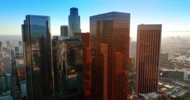 Los Angeles, Kaliforniya 'nın finans merkezindeki muhteşem gökdelenlerin etrafında uçuşlar. Arka planda puslu şehir manzarası.