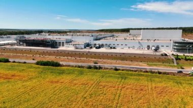 Büyük fabrika boyunca otoban kenarındaki kamyon ve kamyon yolculuğu. Tarlalarda devasa bir modern bitki. Üst görünüm.