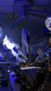 Ortasında Da Vinci robotu olan modern karanlık cerrahi odası. Yazı kalemini kağıt üzerinde yöneten fütürist ekipmanlar. Koğuşta çelenkler açık. Dikey video