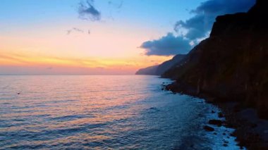 Portekiz 'in Madeira Adaları' nın kayalık sahillerindeki Atlantik Okyanusu. Gün batımında deniz manzarası üzerinde drone görüntüleri.