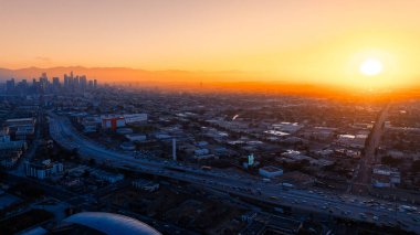Şehir merkezine büyük bir ulaşım akışı var. Gün batımında Los Angeles, Kaliforniya 'nın puslu manzarası. Üst görünüm.
