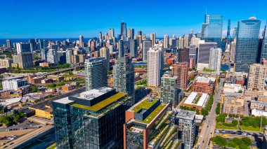 Chicago, Illinois, ABD merkezindeki yüksek binalara uçuyor. Binaların cepheleri parlak yaz güneşiyle aydınlanıyor..