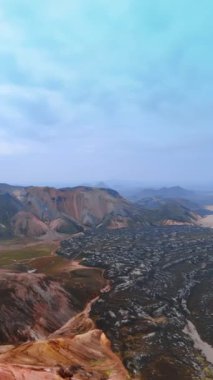 İzlanda 'nın muhteşem kayalık manzarası. Farklı yükseklik ve renkte kayaların ve tepelerin çeşitliliği. Dikey video.