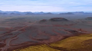 Uyuyan volkan kraterleriyle gerçekçi olmayan kozmik manzaranın üzerinde uçmak. İnsansız hava aracından İzlanda 'nın dünya dışı manzarası.