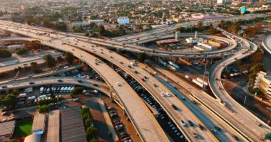 Los Angeles, Kaliforniya, ABD 'nin karmaşık otoyol sisteminin yanından geçen sayısız otomobil var. Gün batımında metropolün kesişiminin en üst görüntüsü.