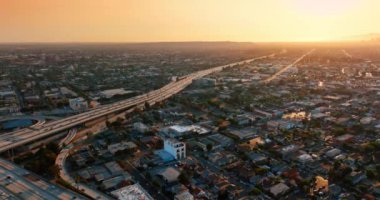 Ulaşım akışı büyük metropolün otobanlarından geliyor. Günbatımı manzarası Los Angeles, California, ABD 'de. Hava görünümü.