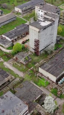 Terk edilmiş büyük bir bitki bölgesi. Eski bir fabrikanın hasarlı binaları. İlkbaharda endüstri mahvoldu. Hava görüntüsü. Dikey video