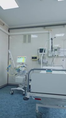 Klinikteki boş resüsitasyon odası. Hastane yatağı modern tıbbi ekipmanlarla birlikte yoğun bakım ünitesinde. Temiz acil servis. Dikey video