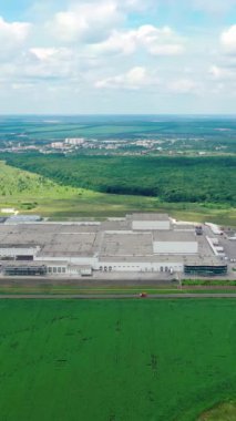 Doğada büyük bir fabrika. Kırsal kesimdeki endüstriyel kompleksin panoramik görüntüsü. Yeşil alanda sanayi bölgesi. Havadan bak. Dikey video
